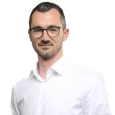 Professionelles Porträt eines Mannes in weißem Hemd Der Mann in einem weißen Hemd hat einen freundlichen Gesichtsausdruck und steht vor einem neutralen Hintergrund.