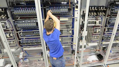 Ein Elektriker der an einem Schaltschrank arbeitet