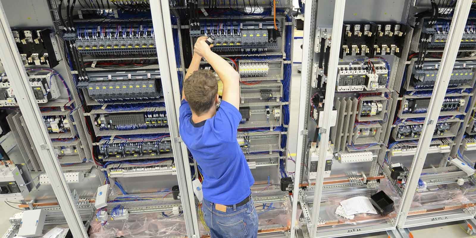Ein Elektriker der an einem Schaltschrank arbeitet